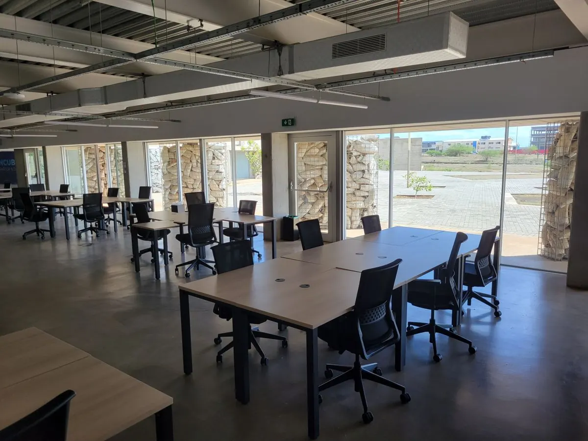 Espaço de coworking com mesas e grandes janelas