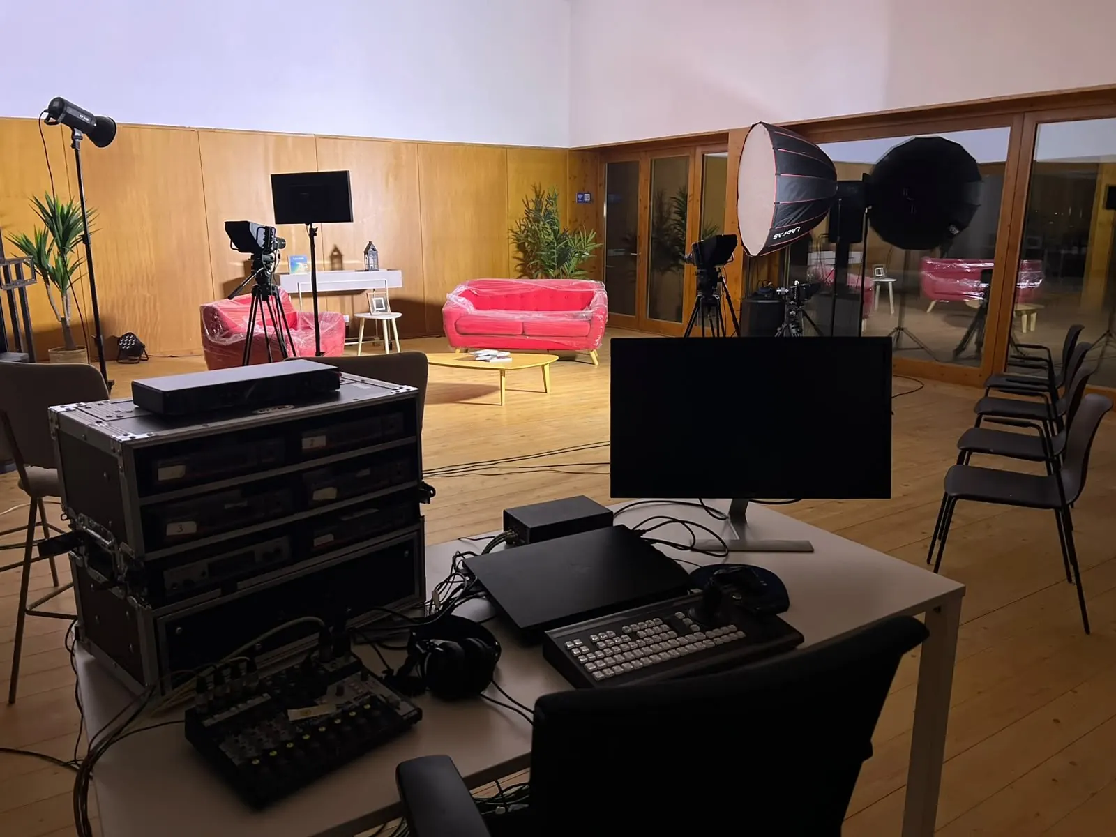 Sala multimédia com câmaras, luzes e sofás vermelhos